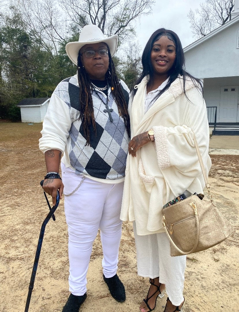 black Lesbian couple standing outside of church proudly