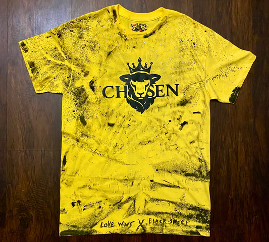 Yellow t-shirt with black graphic design on a wooden surface black sheep