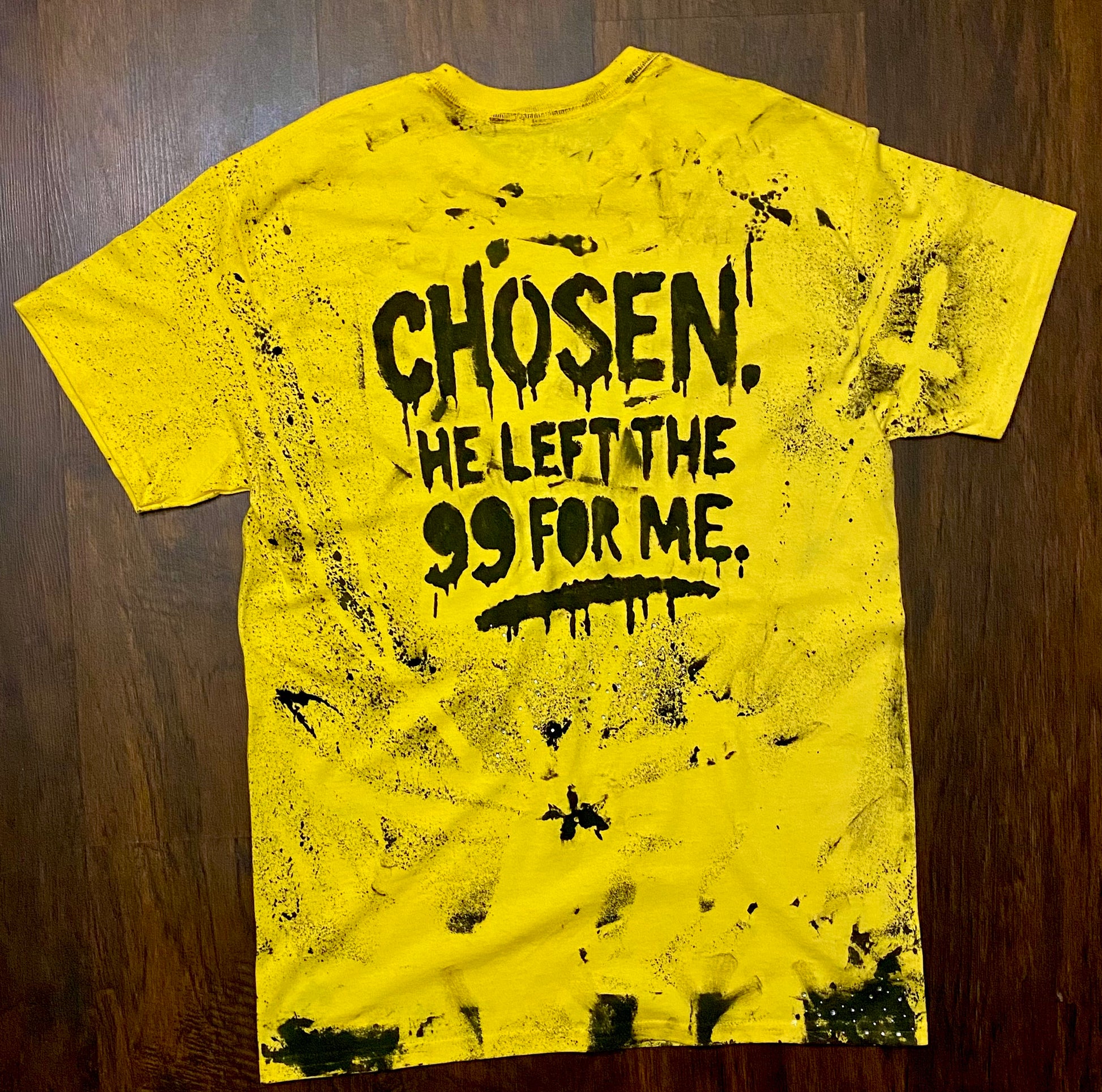 Yellow t-shirt with black text on a wooden surface